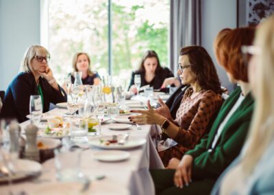 a group of women sitting around a table talking networking photo