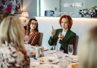 a group of women sitting around a dinner table networking photo